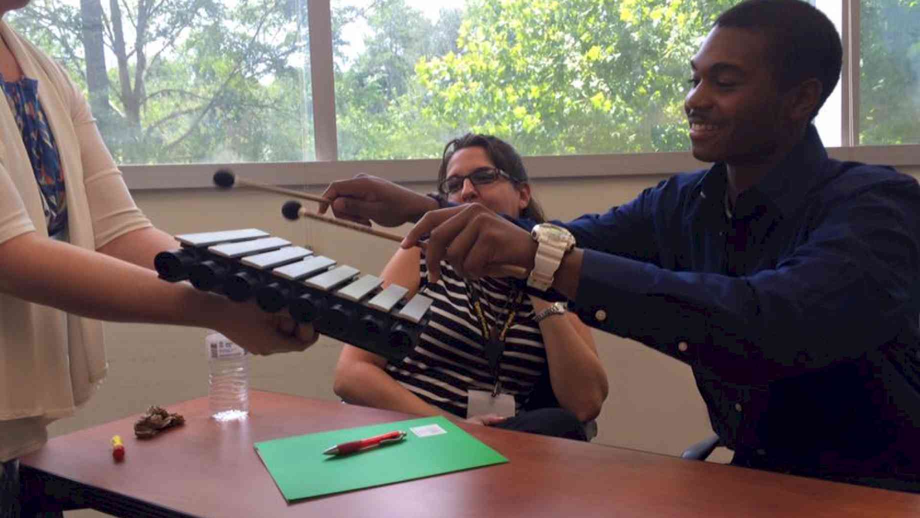 A musician-in-residence demonstrates simple instruments that they use in the hospital for bedside visits.