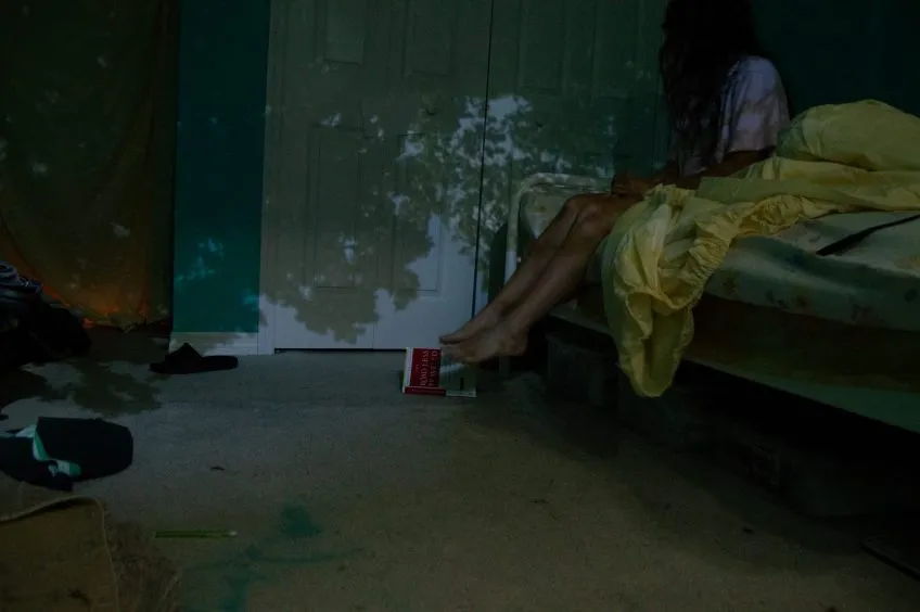 Twilight photo of bedroom with shadows of trees projected on the walls.