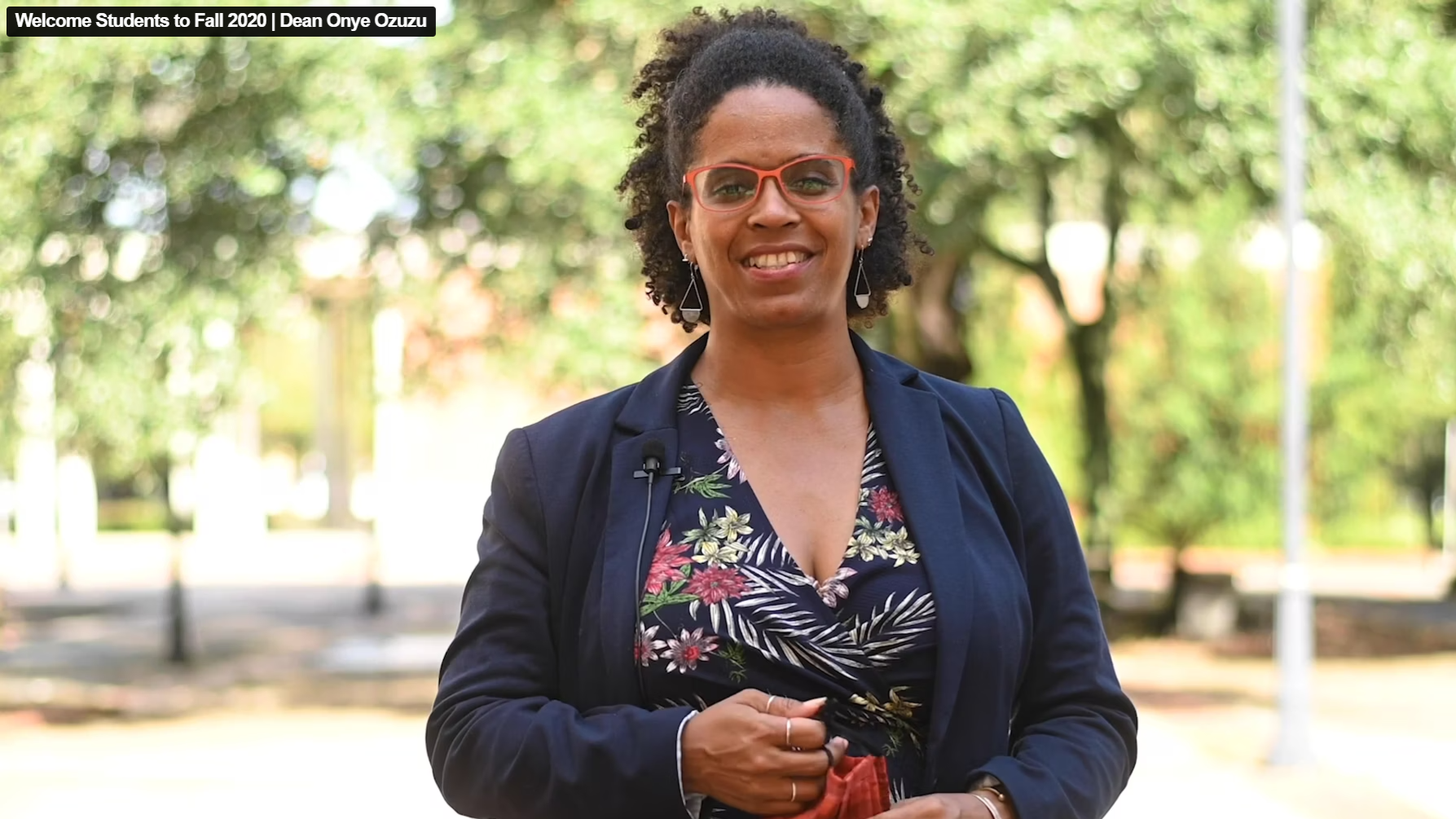 Video still of Dean Ozuzu speaking to the camera, outdoors on campus.