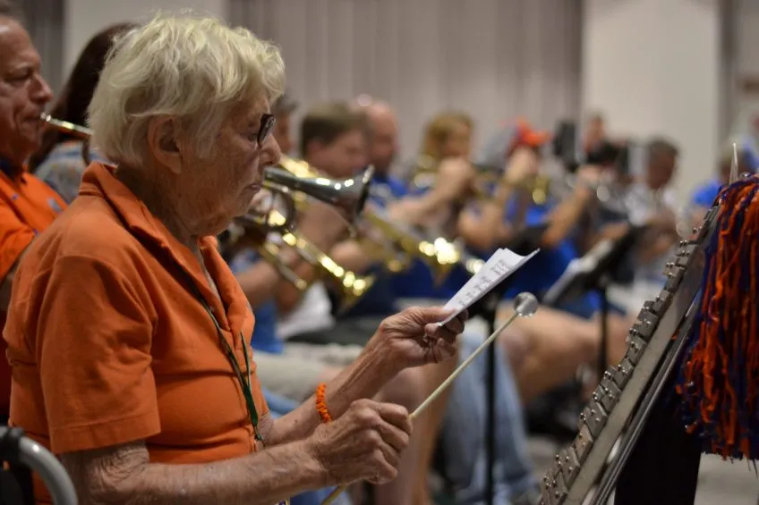Sophy Mae Mitchell plays the bell lyre with Gator Band alumni