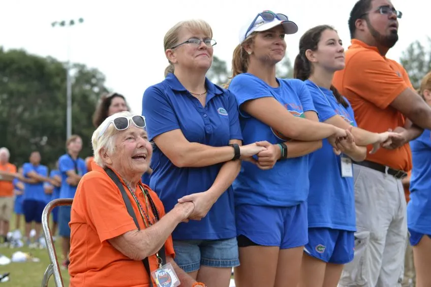 A group of Gator Band alumni holding hands and singing the UF Alma Mater
