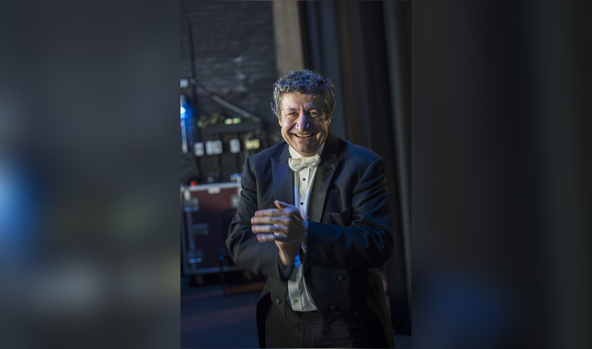 Steven Thomas pictured from the waist up wearing formal wear and smiling.