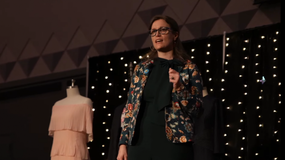 Jennifer Dasher speaks on stage at TEDxUF. A dress form mannequin is in the background.