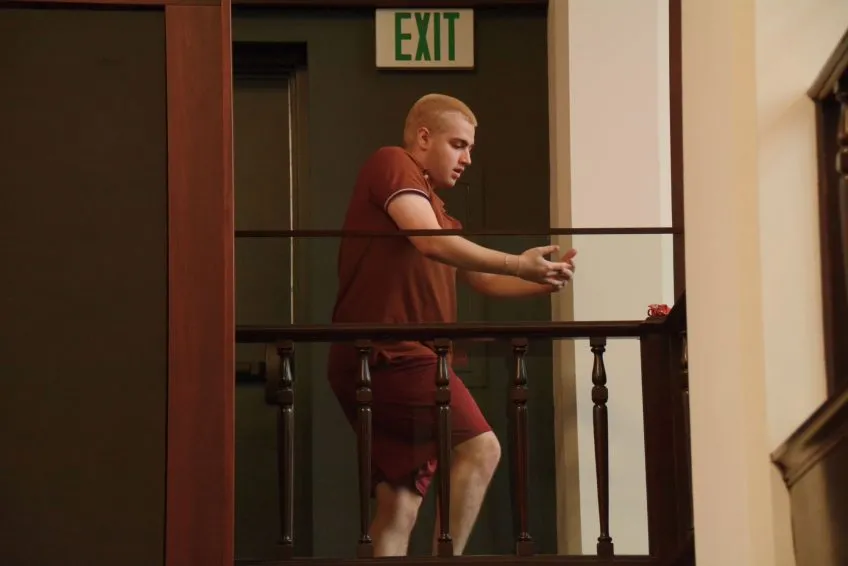 A dancer mid-movement in a library alcove or balcony.
