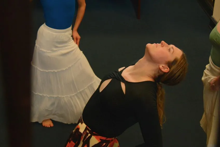 Overhead view of a dancer in motion, with back arched and facing upward.