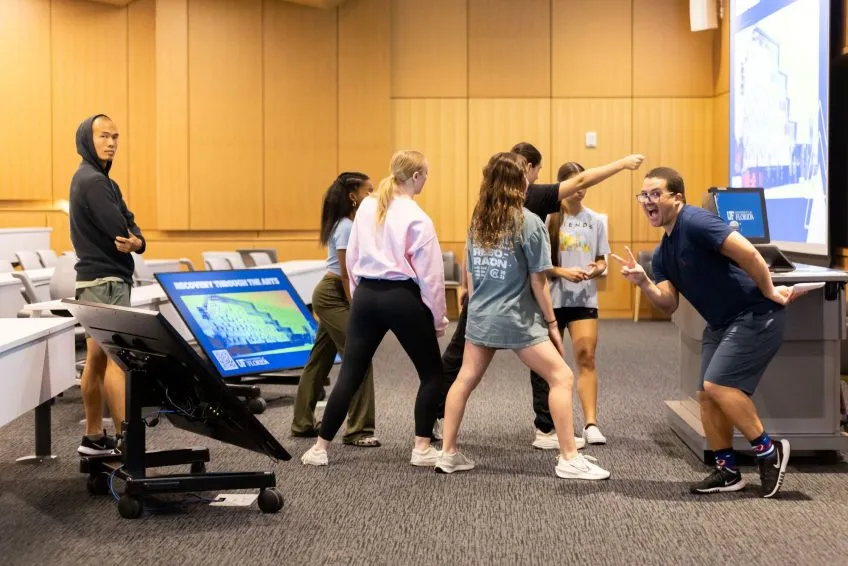 A group of people in mixed motion, in a lecture hall setting.