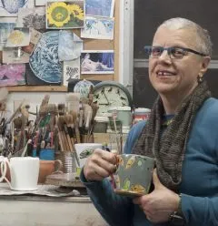 Headshot photo of Linda J Arbuckle in an art studio