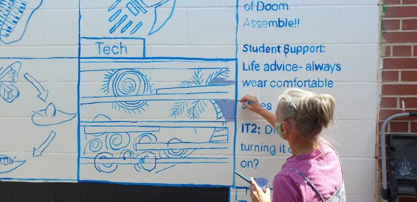 A woman painting a mural