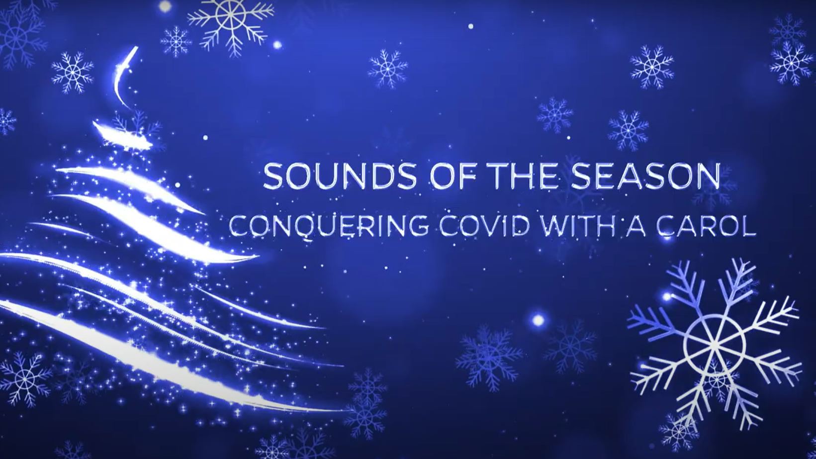 Video still of title graphic "Sounds of the Season: Conquering COVID with a Carol" with holiday tree and snowflakes on blue background