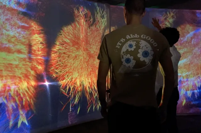 Two students in front of a colorful screen using AI tools.