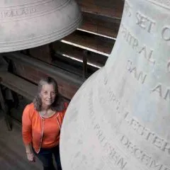 Headshot photo of Laura Ellis with carillon bells