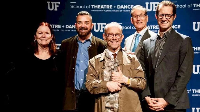 A group of 5 people in front of a School of Theatre and Dance step-and-repeat backdrop