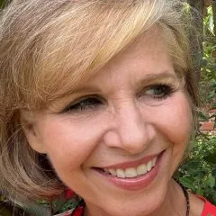Close-up headshot of Angela Jonas, smiling and looking to the right.