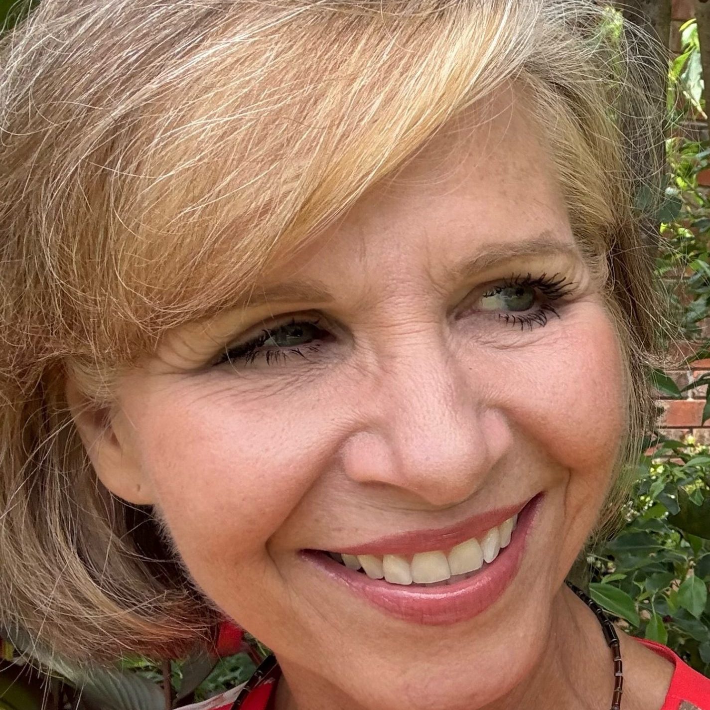 Close-up headshot of Angela Jonas, smiling and looking to the right.