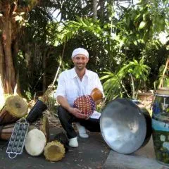 Headshot photo of Kenneth C. Metzker with an assortment of drums