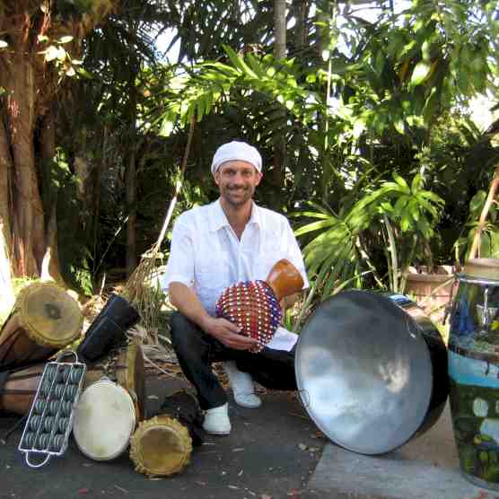Headshot photo of Kenneth C. Metzker with an assortment of drums