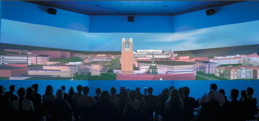 A large group of people viewing a digital tour of UF campus on a panoramic screen, circa early 2000s.