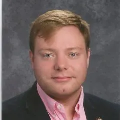 Image of John-Peter looking directly at the camera. John-Peter has short blonde hair and is wearing a pink shirt and a dark grey suit jacket.