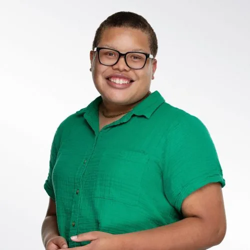 Image of Solana. Solana has short brown hair and is wearing a green blouse.