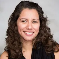 Image of Stephanie. Stephanie is wearing a black shirt and has shoulder length curly brown hair