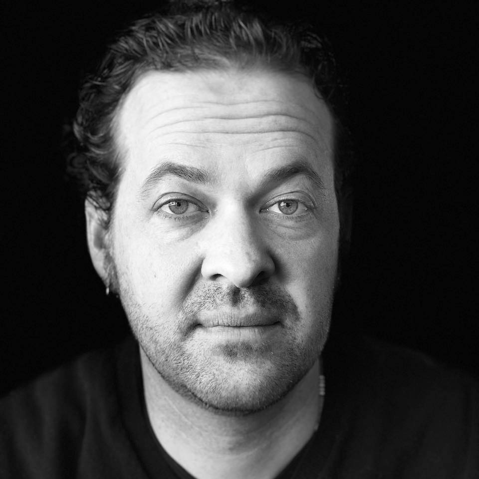 Image of Cody in black and white photography style. Cody has short hair and is wearing a dark shirt.