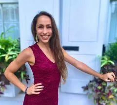 Image of Holly with a dark pink dress on and long brown hair