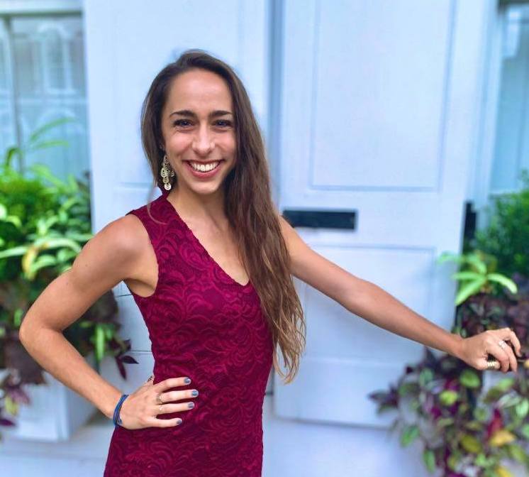 Image of Holly with a dark pink dress on and long brown hair