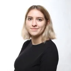 Image of Cordelia. Cordelia has shoulder length brown/blonde hair and is wearing a black shirt.