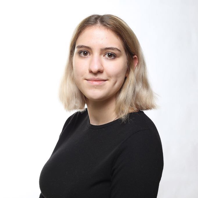 Image of Cordelia. Cordelia has shoulder length brown/blonde hair and is wearing a black shirt.