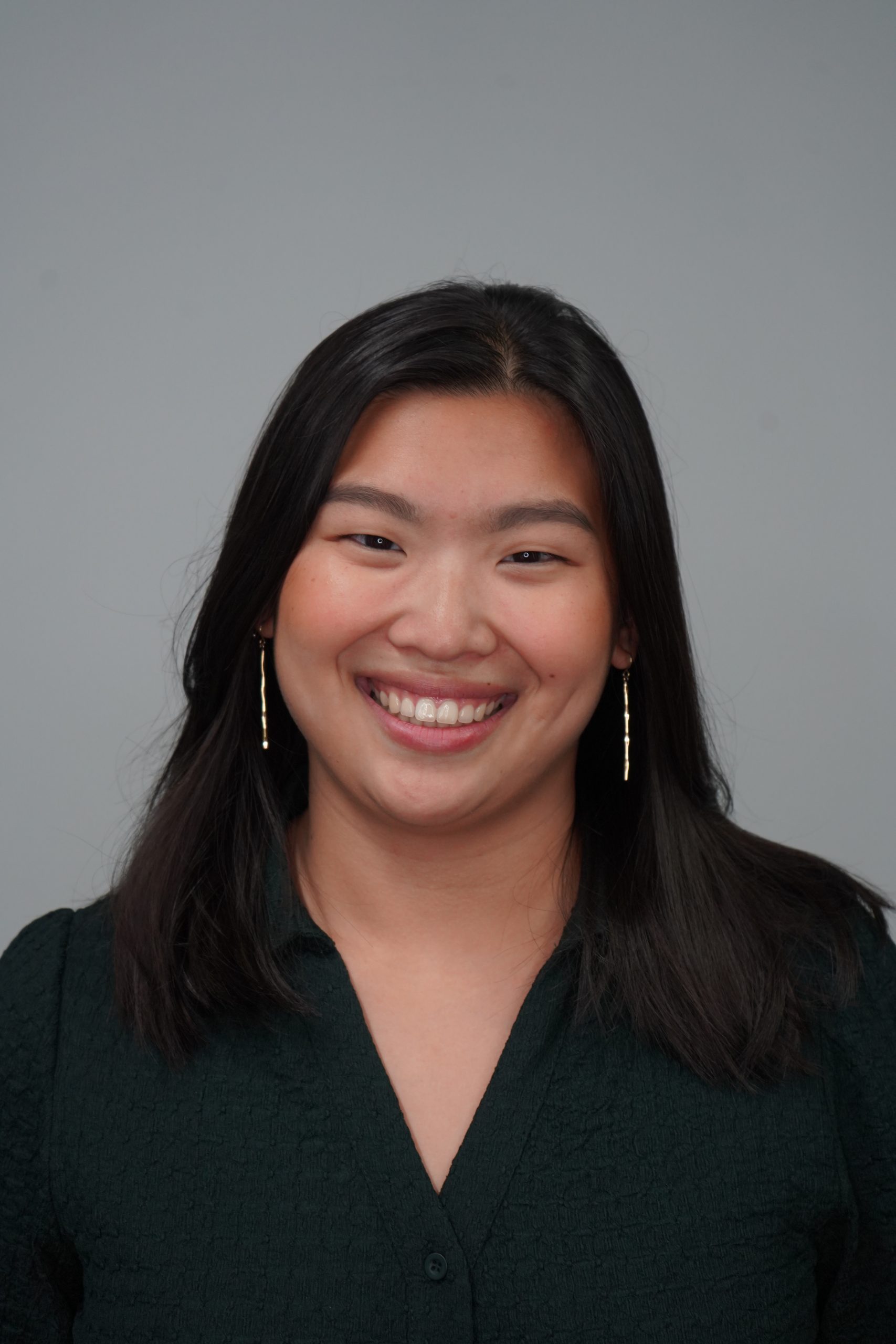 Image of Maile. Maile has shoulder length brown hair and is wearing a dark green blouse