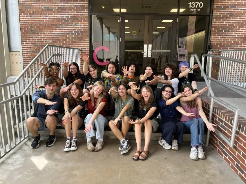 Group of School of Art and Art History Ambassadors sitting on the steps of the Fine Arts Building C.
