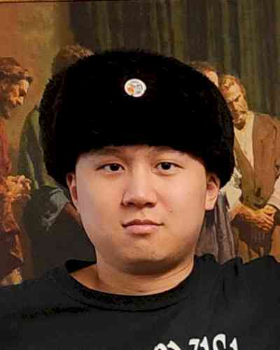 Photo of Frank Sang. Frank is wearing a black fur hat and has a black shirt on