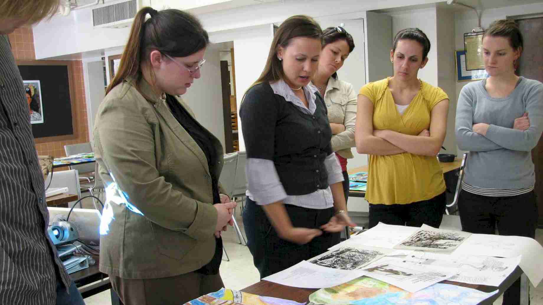 Art education student teachers meet to discuss student art from each of their internship school placements.