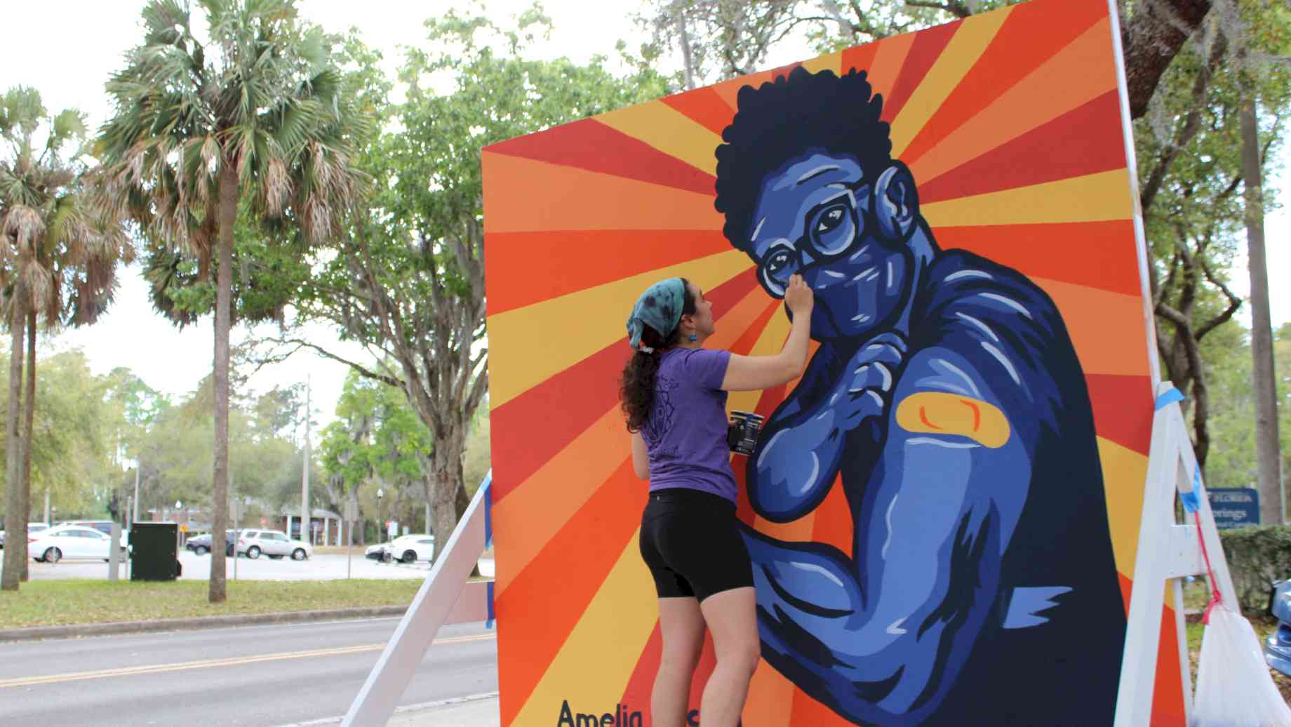 Community artist, Amelia Lindroth, paints a mural at UF